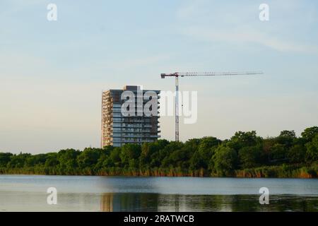Complesso di appartamenti in costruzione e gru alta sulla riva del lago Fundeni a Bucarest Foto Stock