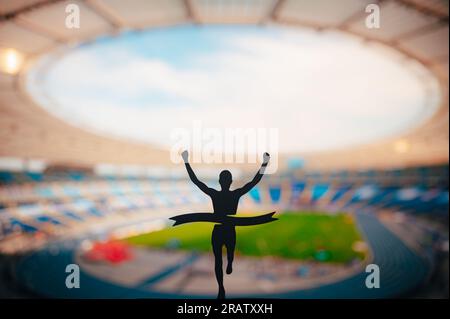 Champion's Triumph: La silhouette di Runner conquista il traguardo al Modern Athletics Stadium. Modifica la foto del concorso spazio, Track and Field. Foto Stock