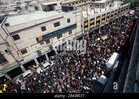 Jenin, Palestina. 5 luglio 2023. I luttuosi portano i corpi di uomini palestinesi, alcuni dei quali rivestiti dalle bandiere del gruppo militante della Jihad islamica e Hamas durante i loro funerali, nel campo profughi di Jenin, in Cisgiordania. L'esercito israeliano afferma di aver ritirato le proprie truppe dal campo mercoledì, ponendo fine a un'intensa operazione di due giorni che ha ucciso almeno 13 palestinesi, ha allontanato migliaia di persone dalle loro case e ha lasciato un'ampia serie di danni sulla scia. Anche un soldato israeliano è stato ucciso. (Foto di Nasser Ishtayeh/SOPA Images/Sipa USA) credito: SIPA USA/Alamy Live News Foto Stock