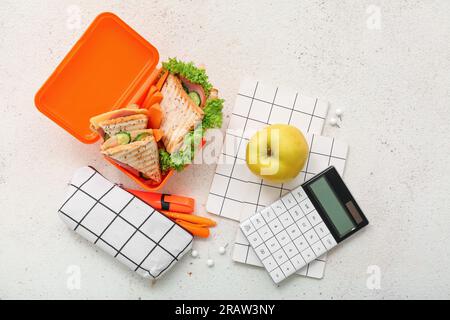 Cancelleria e pranzo al sacco con gustosi piatti su sfondo leggero e grunge Foto Stock