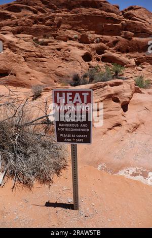 Un cartello di avvertimento termico situato presso la testa di coda del serbatoio del mouse di fronte a una grande formazione di arenaria rossa nel deserto nel Valley of Fire State Park, Foto Stock