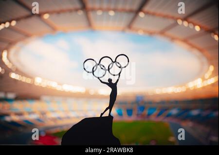 PARIGI, FRANCIA, 7 LUGLIO 2023: Foto in bianco e nero. Spirito Olimpico: La statua dell'atleta tiene l'Olympic Circle High presso il moderno Stadio Olimpico. Acquisizione di t Foto Stock