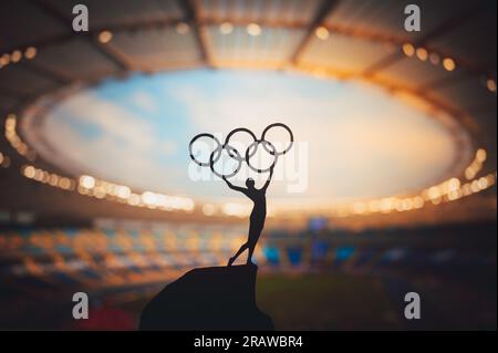 PARIGI, FRANCIA, 7 LUGLIO 2023: Foto in bianco e nero. Spirito Olimpico: La statua dell'atleta tiene l'Olympic Circle High presso il moderno Stadio Olimpico. Acquisizione di t Foto Stock