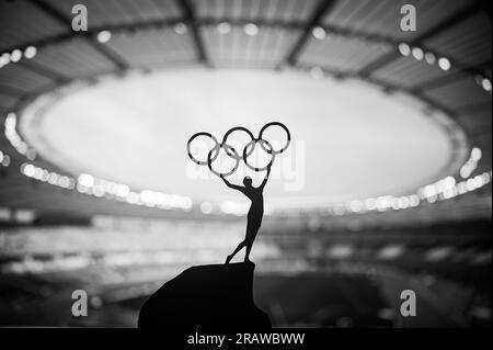 PARIGI, FRANCIA, 7 LUGLIO 2023: Foto in bianco e nero. Spirito Olimpico: La statua dell'atleta tiene l'Olympic Circle High presso il moderno Stadio Olimpico. Acquisizione di t Foto Stock