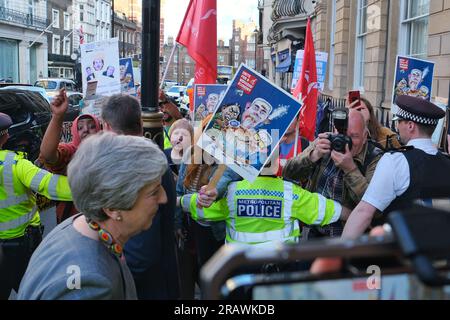 Londra, Regno Unito. 5 luglio 2023. L'ex primo ministro Theresa May si confronta con i membri dell'Unione che protestano contro i membri esterni del Carlton Club, prima di una cena del Partito Conservatore NHS, che celebra il 75° anniversario della sua fondazione. I manifestanti pro-NHS sostengono che il cronico sottofinanziamento e la retribuzione al di sotto dell'inflazione hanno portato a registrare il numero di posti vacanti per il personale e a una grave interruzione dei servizi ai pazienti. Credito: Fotografia dell'undicesima ora/Alamy Live News Foto Stock