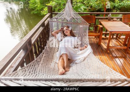 La giovane donna ama la natura e la bellezza mentre si rilassa su un'amaca Foto Stock