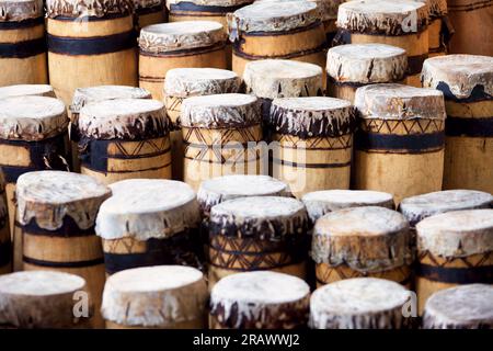 souvenir d'arte africana per gruppi turistici di tamburi fatti a mano in legno e pelle Foto Stock