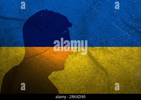 Silhouette del Presidente dell'Ucraina Volodymyr Zelenskyy sullo sfondo della bandiera Ucraina con rivestimento in tessuto grunge. Foto Stock