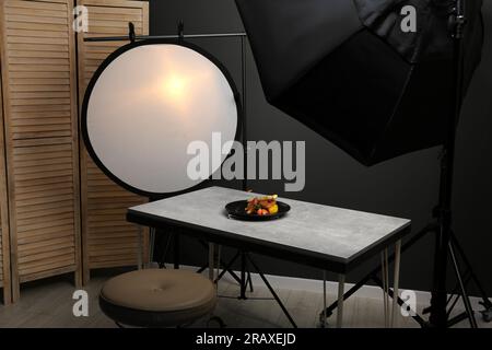 Composizione con pollo al forno, pastinaca e fragole su tavolo grigio in studio fotografico professionale. Fotografia di cibo Foto Stock