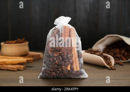 Bustina profumata con chicchi di caffè, anice e cannella su un tavolo di legno, primo piano Foto Stock