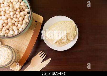 Hummus classico su un piccolo piatto su un tavolo di legno. Vista dall'alto. Foto Stock