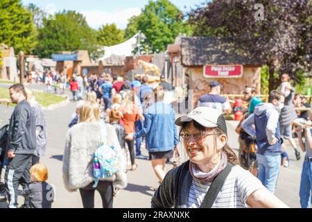 Persone che si godono una giornata di sole in un parco divertimenti Foto Stock