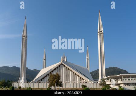 Vista frontale della splendida moschea bianca Faysal in stile turco, punto di riferimento della capitale Islamabad del Pakistan con sfondo montano Foto Stock