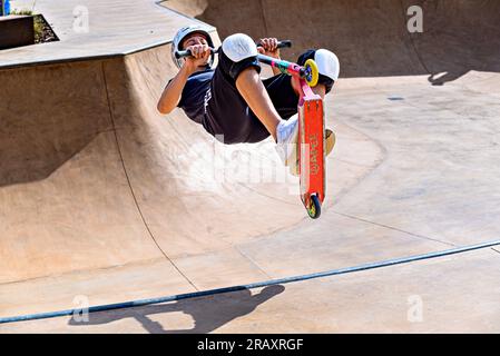 Igualada, Barcellona; 28 giugno 2023: Giovane praticante Scootering (Freestyle Scootering) nel nuovo Skatepark del parco centrale di Igualada, Barce Foto Stock