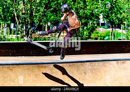 Igualada, Barcellona; 28 giugno 2023: Giovane praticante Scootering (Freestyle Scootering) nel nuovo Skatepark del parco centrale di Igualada, Barce Foto Stock