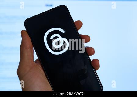 In questa foto, il logo dei thread dell'app di Meta è visibile sul display di un telefono cellulare e sullo schermo di un laptop. Thread è il lat Foto Stock