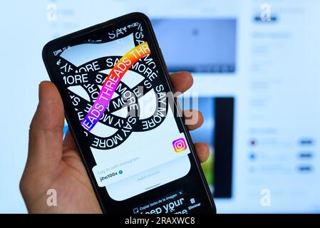 In questa foto, i thread dell'app di Meta sono visualizzati sul display di un telefono cellulare con il feed Twitter in background. Threads è tardi Foto Stock