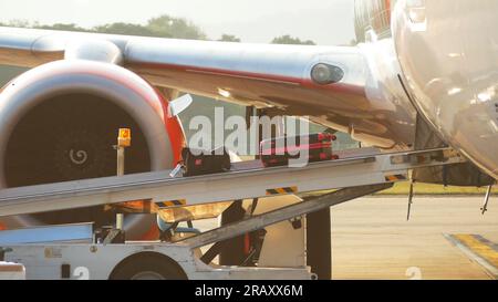 Processo di portare i bagagli borsa su un nastro trasportatore aereo prima della partenza durante il viaggio in aeroporto Foto Stock