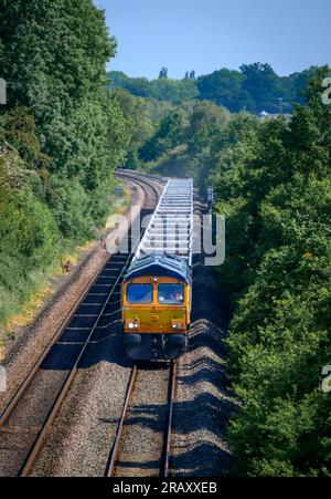 Treno merci GB Railfreight classe 66 che viaggia lungo i binari nel Warwickshire, Inghilterra. Foto Stock