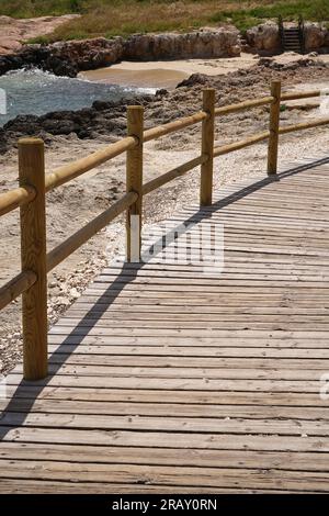 Passerella in legno per la spiaggia di Cala Porto bianco nella pittoresca Monopoli, Puglia, Italia Foto Stock