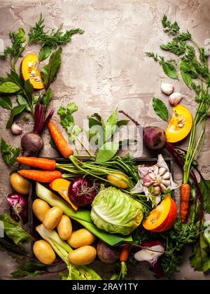 Varietà di ingredienti vegetali crudi freschi per cucinare zuppe o stufati di verdure. Natura morta vegetale autunnale su sfondo rustico vintage. Vista dall'alto Foto Stock