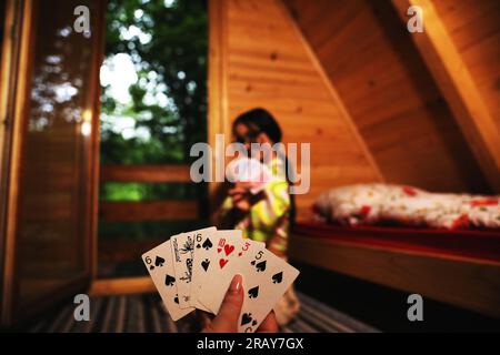 Vivi l'emozione di un gioco di carte con questa immagine accattivante. Un primo piano rivela la mano di una donna in possesso di una carta da gioco, mostrando il Foto Stock