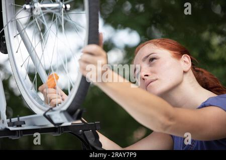 ciclista donna che mette in auto la mountain bike dal rack Foto Stock