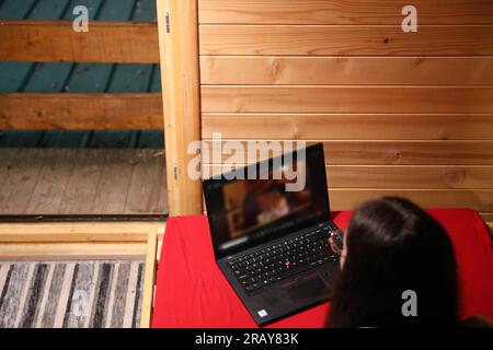 Assisti all'era moderna dell'istruzione online quando una giovane donna felice lavora sul suo notebook a letto Foto Stock