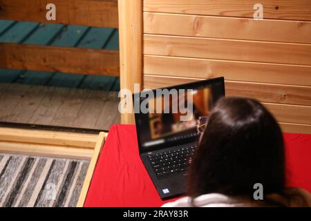 Assisti all'era moderna dell'istruzione online quando una giovane donna felice lavora sul suo notebook a letto Foto Stock