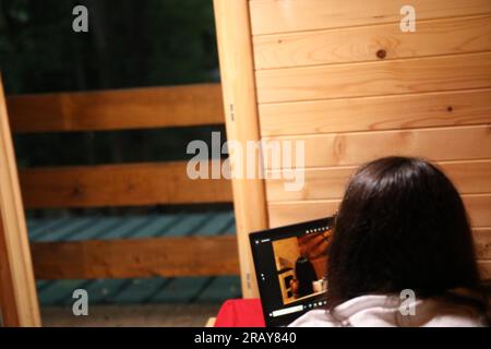 Assisti all'era moderna dell'istruzione online quando una giovane donna felice lavora sul suo notebook a letto Foto Stock