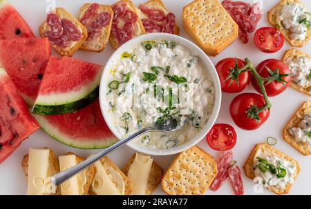 Antipasto con anguria, formaggio e cracker su piatto bianco Foto Stock