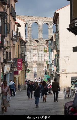 Città vecchia di Segovia, vista delle persone che camminano in Calle Cervantes nella storica zona del centro storico di Segovia con l'acquedotto romano mostrato in lontananza Foto Stock