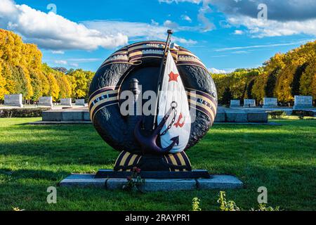 Cappa, corona d'alloro con faro di bandiera sovietica e ancora al Memoriale di guerra sovietico a Treptow Park, Berlino, Germania Foto Stock