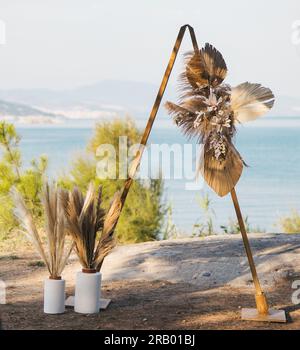 Hochzeitsdekoration mit Kränzen und Blumen / decorazione nuziale con corone, fiori e vaso Foto Stock