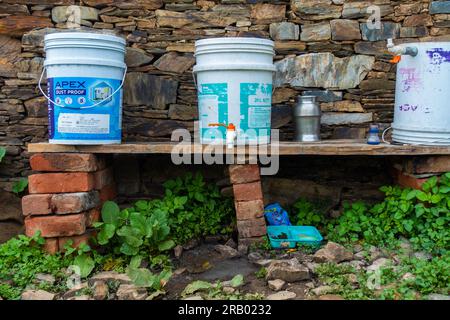 28 giugno 2023, Nagthat, Uttarakhand, India. Un secchio fai da te e un rubinetto installato nel cortile per lavare vestiti e piatti. Uttarakhand India. Foto Stock