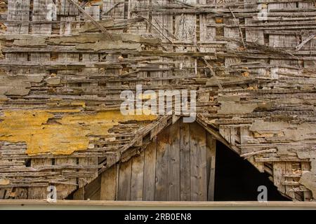 Dettaglio di un vecchio muro di legno in decomposizione dove un tempo era Unito un tetto Foto Stock