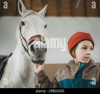 Ragazzo con cavallo nel centro di equitazione Foto Stock