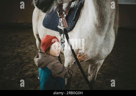 Ragazzo con cavallo nel centro di equitazione Foto Stock