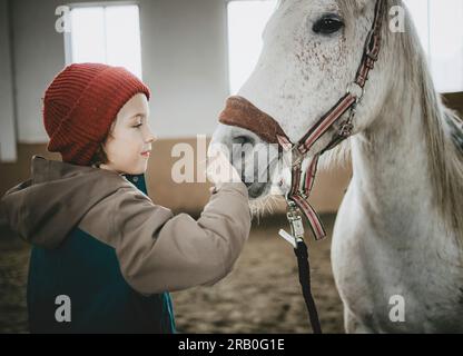 Ragazzo con cavallo nel centro di equitazione Foto Stock