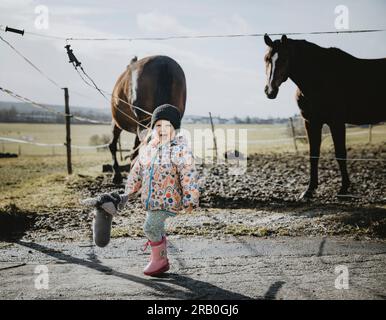 Bambina che cavalca con il suo cavallo da hobby Foto Stock