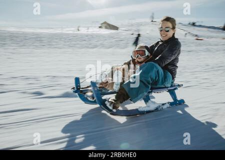 Madre e figlia in slitta Foto Stock