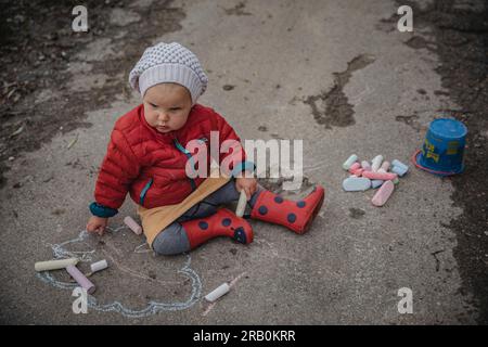 Bambina che disegna con gesso per strada Foto Stock