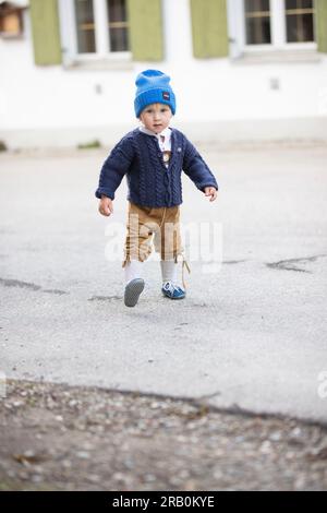 Bambino con pantaloni in pelle, cardigan e berretto in lana Foto Stock