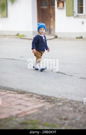 Bambino con pantaloni in pelle, cardigan e berretto in lana Foto Stock