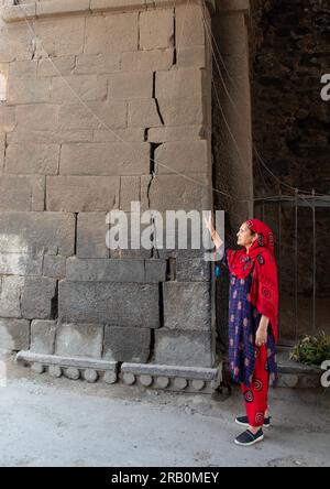 Donna del Kashmir sotto una porta ad arco moghul nelle mura della città vecchia, Jammu e Kashmir, Srinagar, India Foto Stock