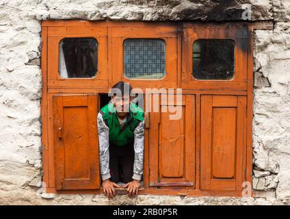 Ragazzo Kashmiri in piedi alla finestra della sua casa, Jammu e Kashmir, Kangan, India Foto Stock
