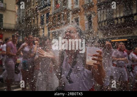 Pamplona, Spagna. 6 luglio 2023. Una giovane donna viene inondata di acqua gettata dai balconi durante le festività di San Fermin. Alle 12:00 sono iniziati i festeggiamenti di San Fermin, con il lancio di "El Chupinazo" dal municipio di Pamplona. Sette giorni di festeggiamenti che attraversano le strade di Pamplona, il chupinazo dà l'inizio della festa, la città di Pamplona non dorme in sette giorni per 24 ore. Corsa di tori, corride, pranzi, cene, gruppi musicali e una buona atmosfera durante i sette giorni di festeggiamenti. Credito: SOPA Images Limited/Alamy Live News Foto Stock