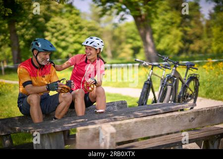 Coppia, uomo e donna che viaggiano in bici, riposo, pausa, trekking, e-bike Foto Stock