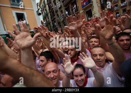 Le persone alzano la mano quando passano le bande musicali durante i festeggiamenti di San Fermin. Alle 12:00 sono iniziati i festeggiamenti di San Fermin, con il lancio di "El Chupinazo" dal municipio di Pamplona. Sette giorni di festeggiamenti che attraversano le strade di Pamplona, il chupinazo dà l'inizio della festa, la città di Pamplona non dorme in sette giorni per 24 ore. Corsa di tori, corride, pranzi, cene, gruppi musicali e una buona atmosfera durante i sette giorni di festeggiamenti. (Foto di Elsa A Bravo/SOPA Images/Sipa USA) Foto Stock