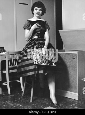 Stati Uniti: c. 1952 Una giovane donna intensamente ascoltando l'album discografico Greensleeves della Montovani Orchestra. Foto Stock